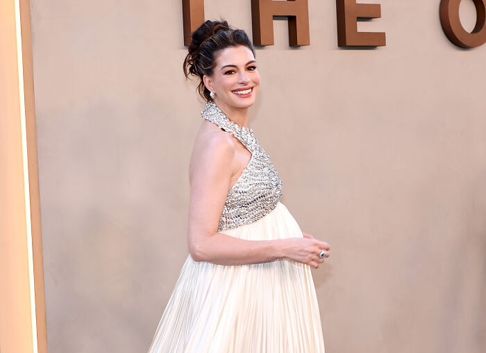 Anne Hathaway pregnant on the red carpet, smiling. Anne Hathaway pregnant on the red carpet, smiling.