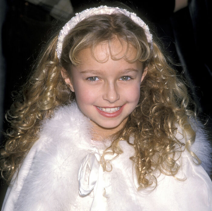 Young Hayden Panettiere smiling with curly hair and a white fur-trimmed outfit. Young Hayden Panettiere smiling with curly hair and a white fur-trimmed outfit.