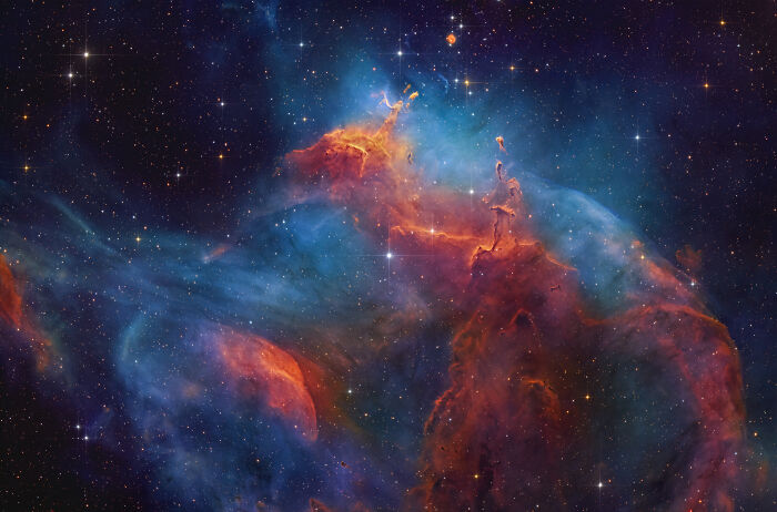 Vibrant cosmic pillars and nebulae in a rich field of stars, showcasing astronomy photos.