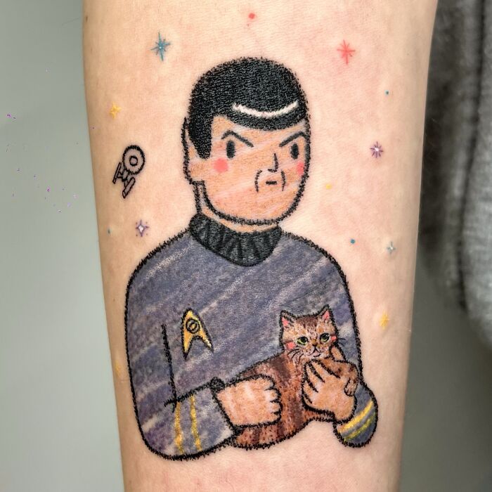 Unique Spock with cat tattoo, mimicking crayon drawings, showing childhood creativity and artistic tattoos.