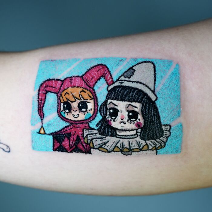 Artistic crayon drawing-inspired tattoo of two characters in jester outfits, capturing the essence of childhood creativity.