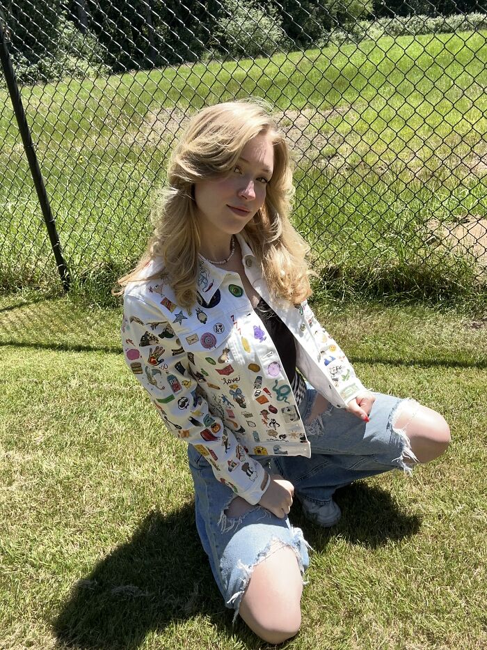 Young woman wearing a white jacket covered in Gen-Z pop culture patches outdoors