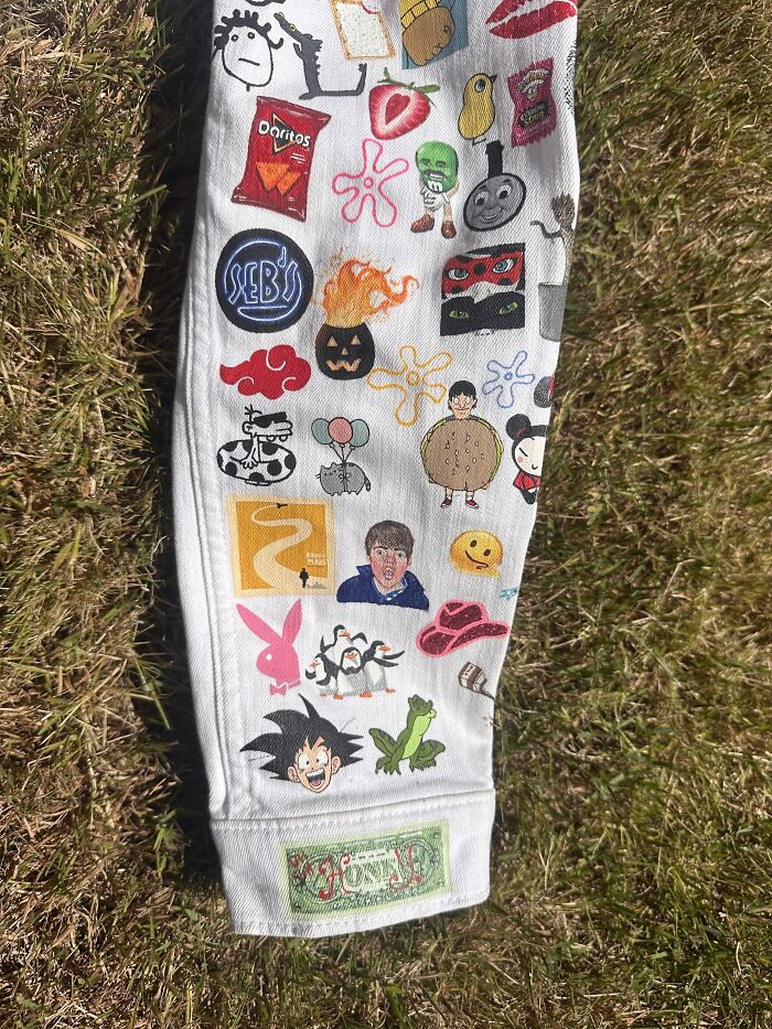 Close-up of the right sleeve of a white denim jacket, featuring numerous pop culture images from Gen-Z childhood.