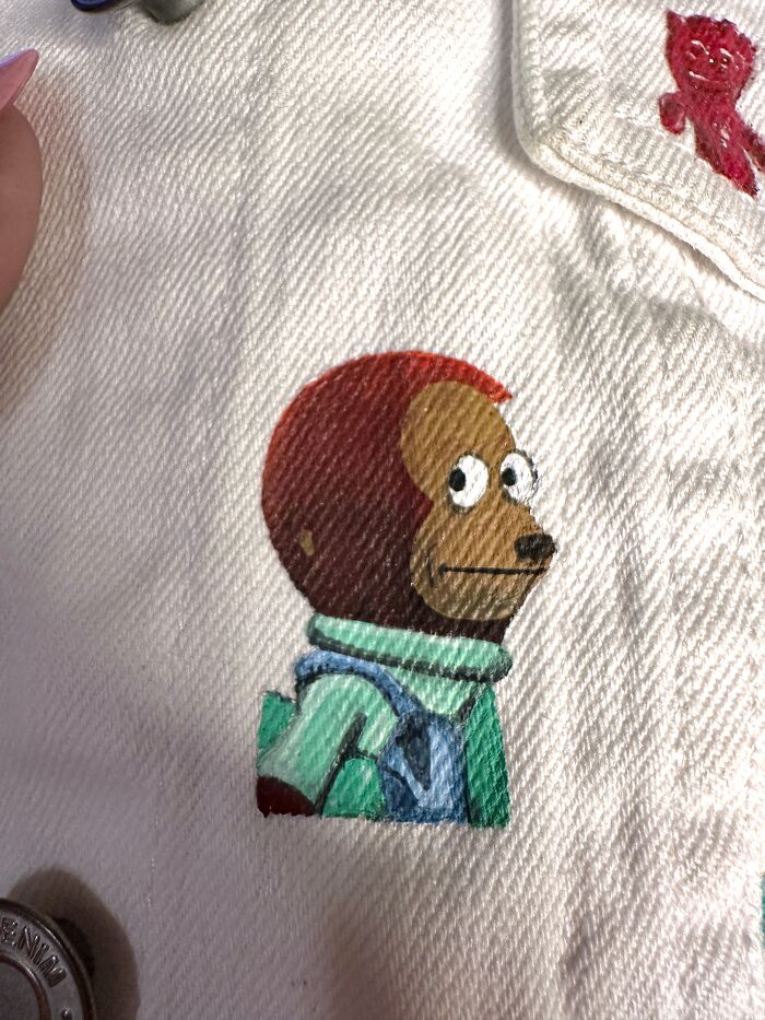 A hand-painted monkey puppet meme on a jacket, part of a larger collection of pop culture from Gen-Z's childhood.