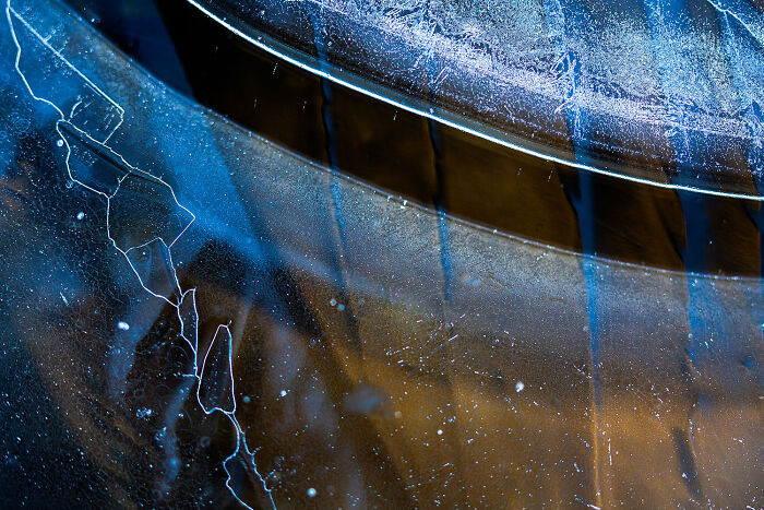 Abstract image of blue and brown ice cracks and patterns, captured at a nature photography festival.