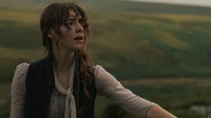 Woman with long brown hair in period attire looking surprised, part of a new Jane Austen adaptation. Woman with long brown hair in period attire looking surprised, part of a new Jane Austen adaptation.
