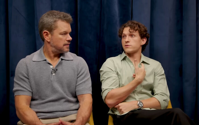 Matt Damon and Tom Holland in a discussion, with Holland gesturing, talking about actors. Matt Damon and Tom Holland in a discussion, with Holland gesturing, talking about actors.