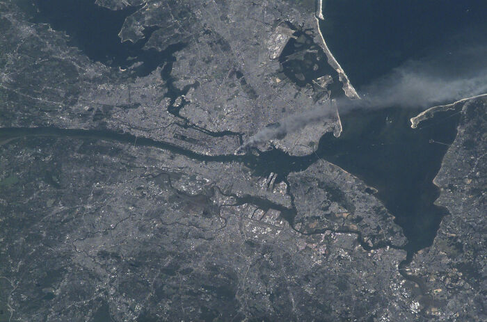 An aerial view of a city with smoke rising from a specific area, a rare and fascinating photo from American history.