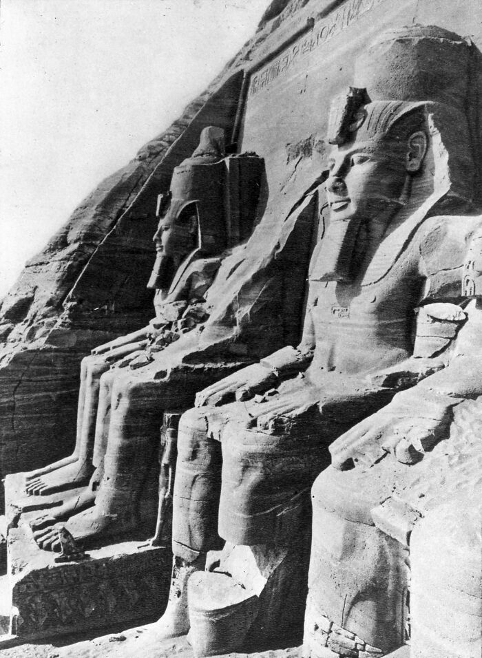 Black and white image of the ancient Abu Simbel temples, showing massive statues of pharaohs, a moment in history.