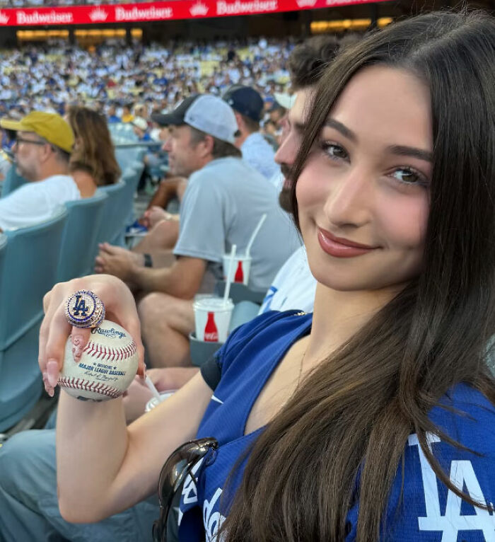 Mario Lopez's niece holding a baseball, smiling, as part of the controversial video.