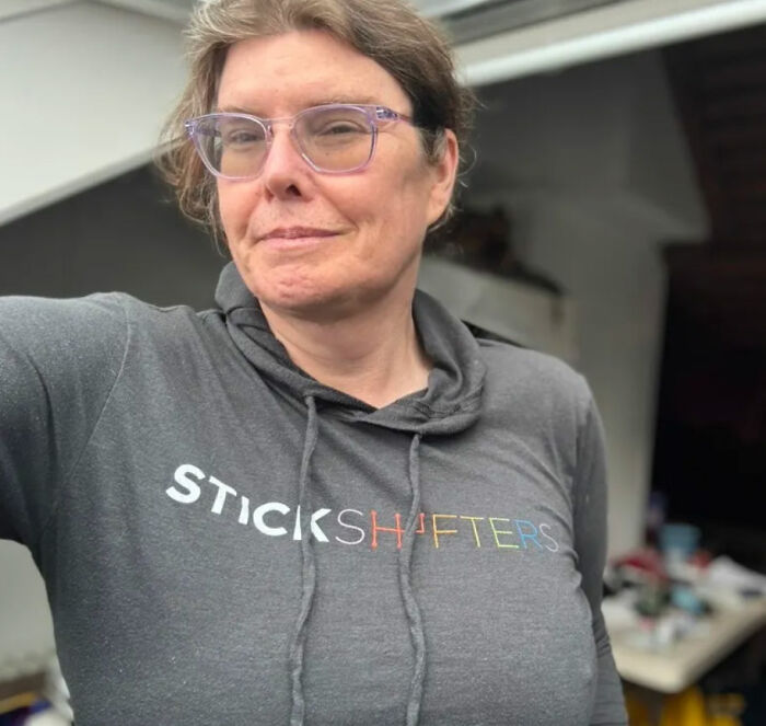 Trans American wearing a gray hoodie, looking directly at the camera, highlighting her return to the US. Trans American wearing a gray hoodie, looking directly at the camera, highlighting her return to the US.
