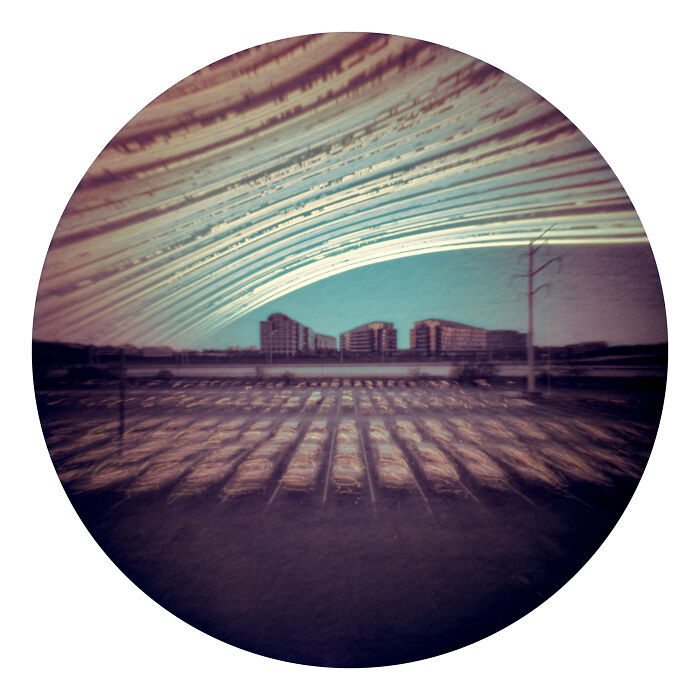 Circular astronomy photo capturing streaking light over urban buildings, a unique view of the universe.