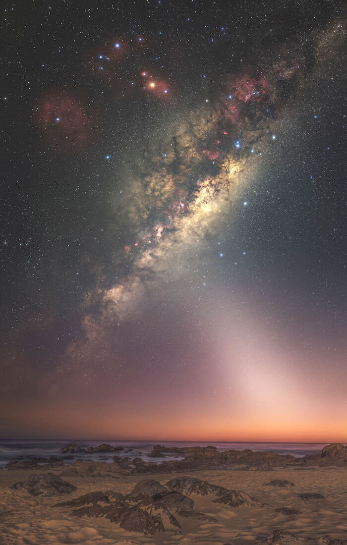 Breathtaking astrophotography image from David Malin Awards, featuring the Milky Way over a coastline at dawn.