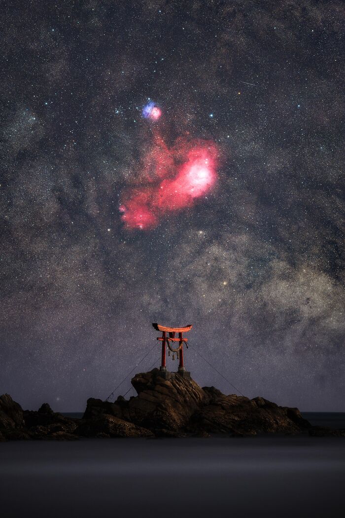 A red torii gate on a rocky outcrop under a vast, star-filled night sky, capturing the essence of astronomy photos.