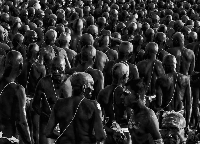 A powerful black and white image of a large crowd of men, capturing an authentic moment in street photography.