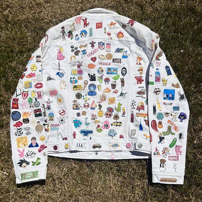 An entire white denim jacket covered in various hand-painted pop culture references, representing Gen-Z's childhood.