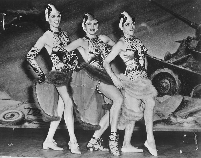 Three performers in elaborate costumes on a stage, a vibrant historical moment nearly lost to history.