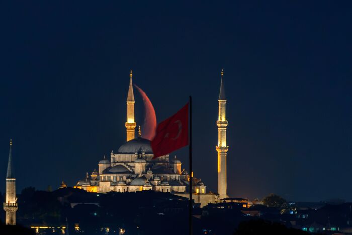 Murat Bakmaz captures the easily missed beauty of a mosque at night with a full moon and Turkish flag.