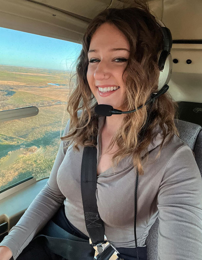 Woman in a cockpit, wearing a headset and smiling, connecting to the US tourist's court fate for a snatched baby wombat. Woman in a cockpit, wearing a headset and smiling, connecting to the US tourist's court fate for a snatched baby wombat.