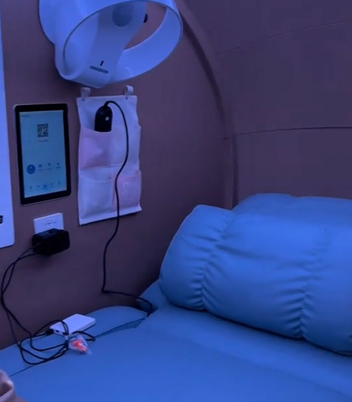 The interior of a futuristic sleeping pod, featuring a comfortable bed, tablet, and charging ports for travelers. The interior of a futuristic sleeping pod, featuring a comfortable bed, tablet, and charging ports for travelers.
