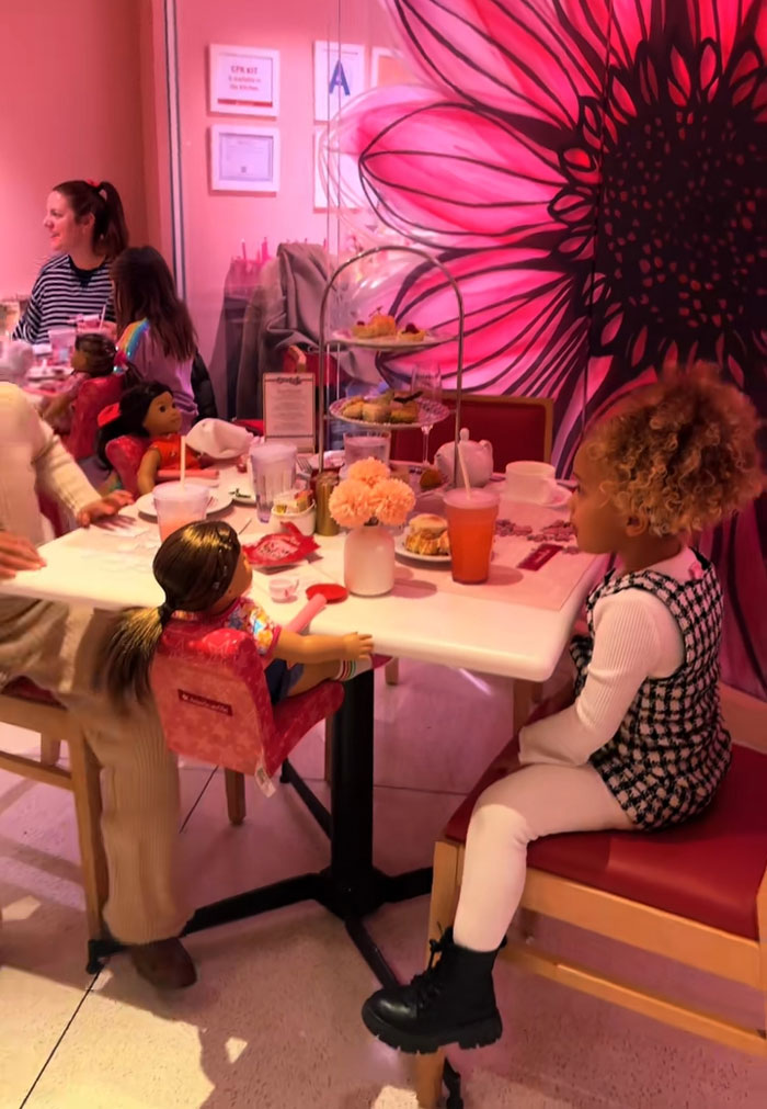 A little girl having a tea party with her doll, showing kids spend their mornings reading and exercising. A little girl having a tea party with her doll, showing kids spend their mornings reading and exercising.