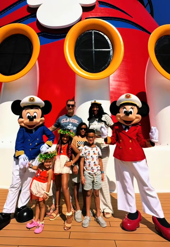 A family with two kids and two Mickey Mouse characters on a Disney cruise, enjoying a vacation. A family with two kids and two Mickey Mouse characters on a Disney cruise, enjoying a vacation.