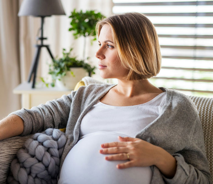 A pregnant woman sits on a couch, illustrating a wife who cheats and makes ludicrous demands. A pregnant woman sits on a couch, illustrating a wife who cheats and makes ludicrous demands.