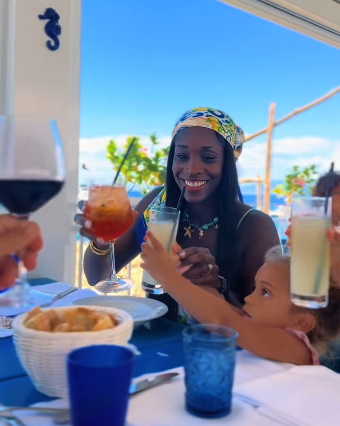 A mom and child toasting drinks at an outdoor restaurant, highlighting quality time with kids after mornings reading and exercising. A mom and child toasting drinks at an outdoor restaurant, highlighting quality time with kids after mornings reading and exercising.