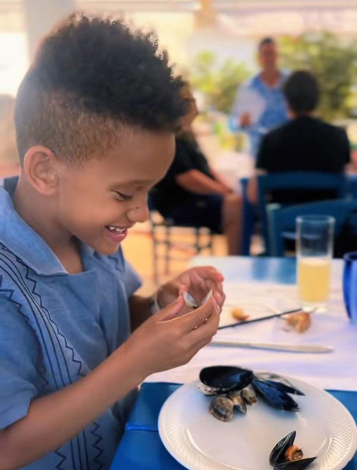 A happy boy reading a shell at a table, enjoying his mornings. A happy boy reading a shell at a table, enjoying his mornings.