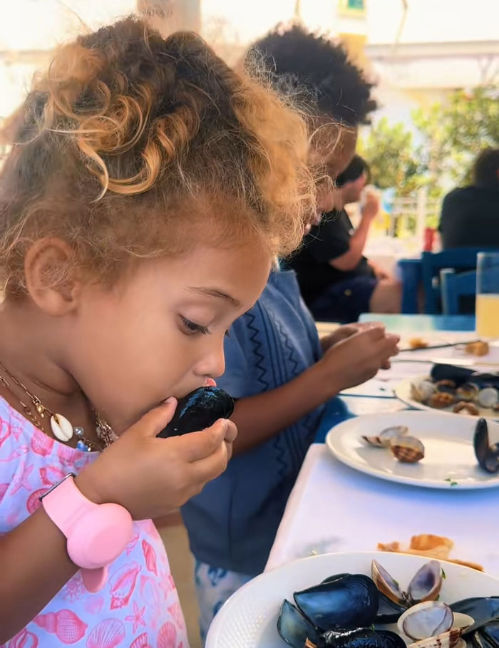 A young girl eating a mussel, showcasing results from her mornings routine. A young girl eating a mussel, showcasing results from her mornings routine.