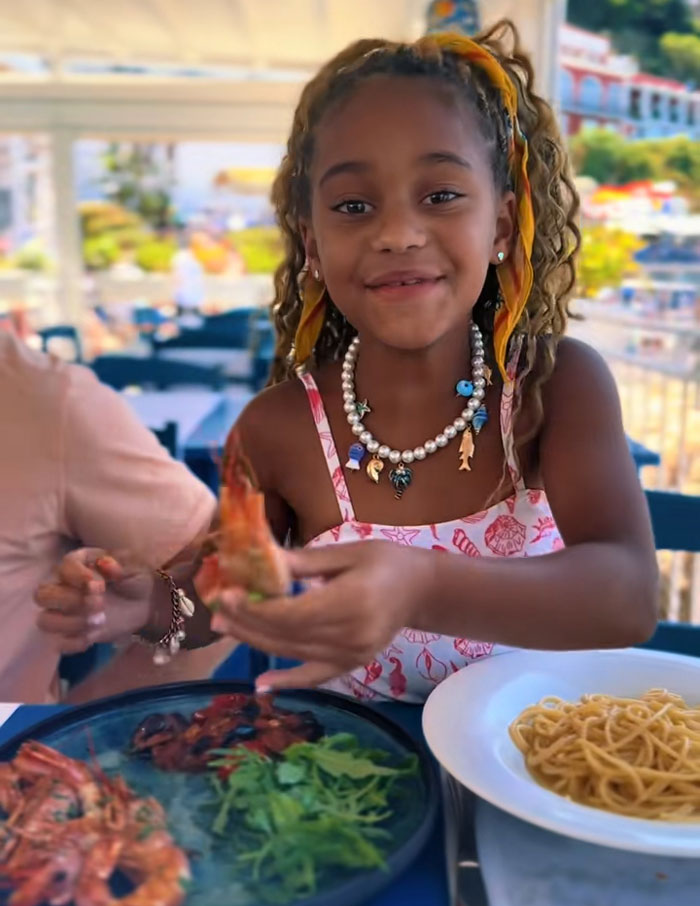 A smiling girl holding a shrimp, demonstrating results from her mornings of exercising. A smiling girl holding a shrimp, demonstrating results from her mornings of exercising.