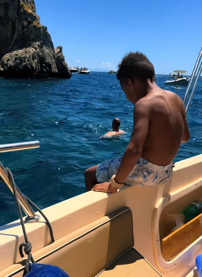 A boy sitting on a boat, enjoying the water, after his mornings of reading and exercising. A boy sitting on a boat, enjoying the water, after his mornings of reading and exercising.
