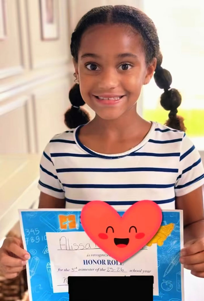 A smiling girl displaying her Honor Roll certificate, showcasing the results of her morning reading and exercising. A smiling girl displaying her Honor Roll certificate, showcasing the results of her morning reading and exercising.