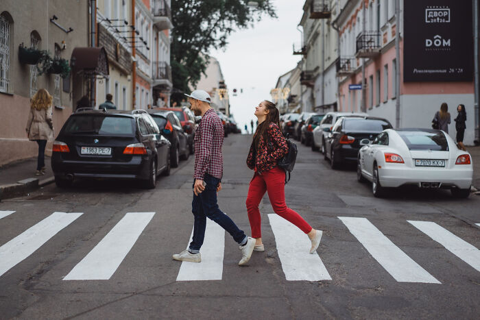Absurd American questions: a couple crosses a street in a European city.