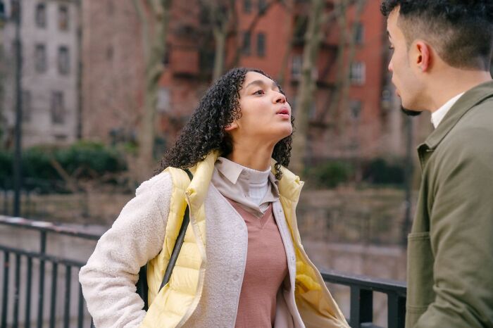 A woman with curly hair confronts a man outdoors, illustrating ridiculous reasons for arguments.