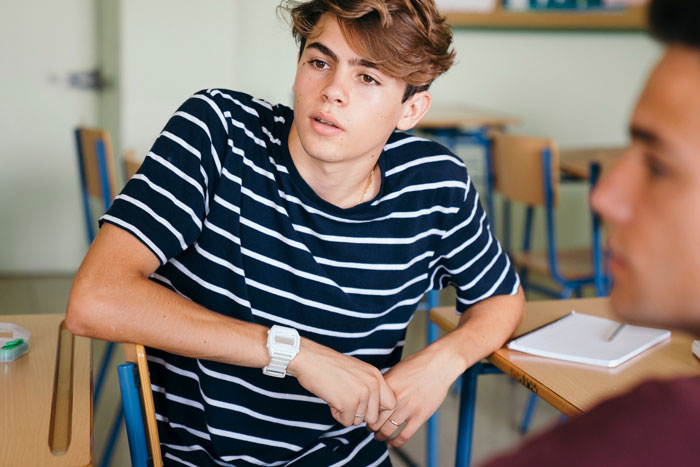 Male classmate socializing with female classmates, feeling intruded upon by his presence. Male classmate socializing with female classmates, feeling intruded upon by his presence.