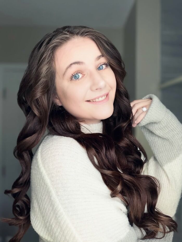 A 23-year-old mother of four with Down Syndrome diagnosis, smiling with long brown hair. A 23-year-old mother of four with Down Syndrome diagnosis, smiling with long brown hair.