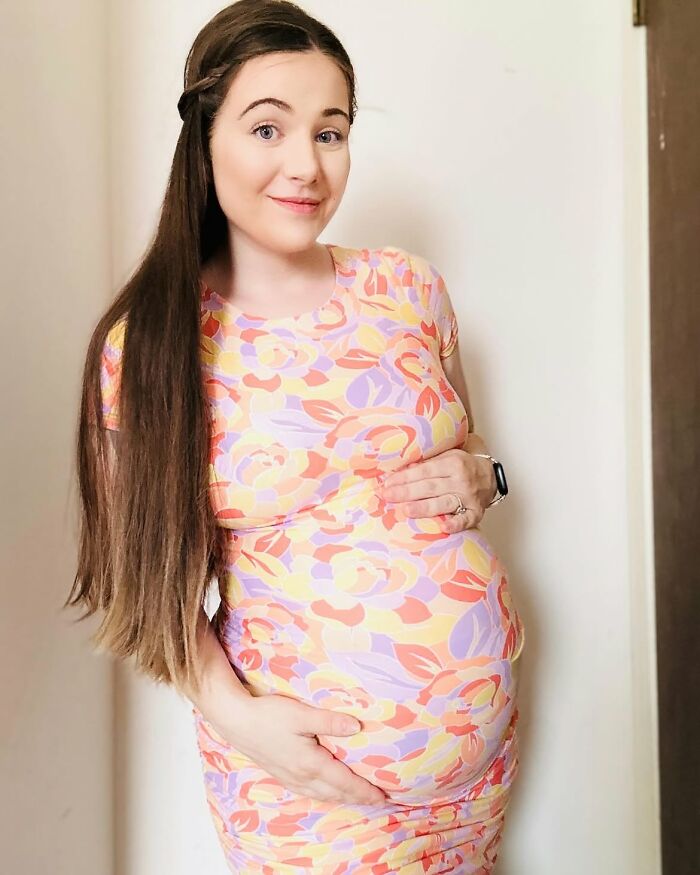 A pregnant mother of four, diagnosed with Down Syndrome, holding her baby bump and smiling. A pregnant mother of four, diagnosed with Down Syndrome, holding her baby bump and smiling.
