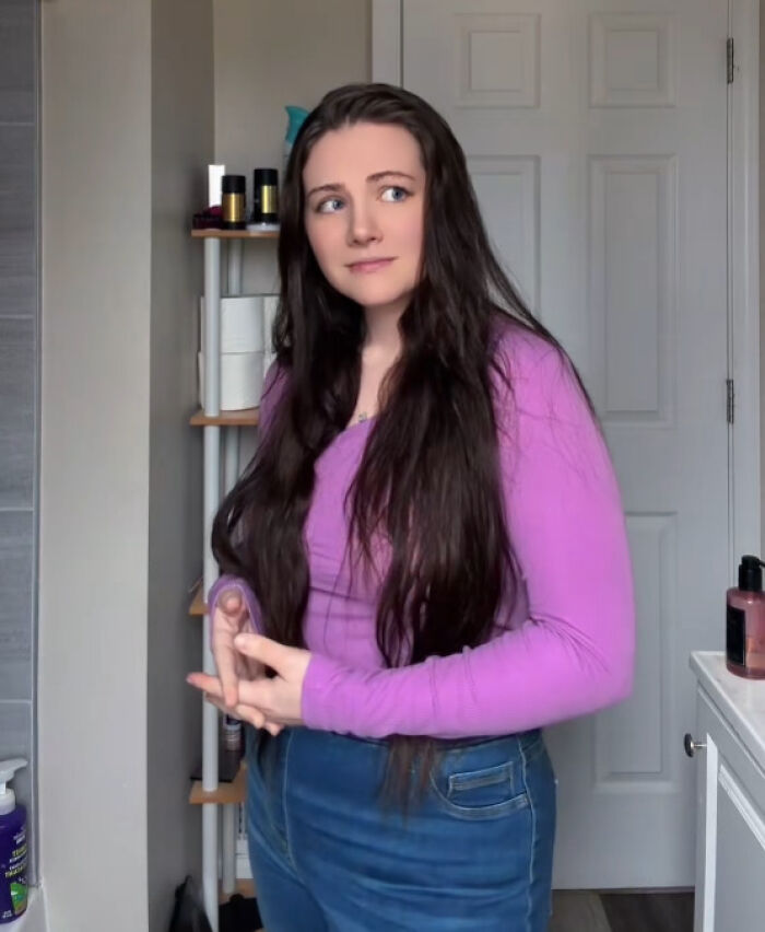 A mother of four, diagnosed with Down Syndrome, standing in a bathroom, looking pensive. A mother of four, diagnosed with Down Syndrome, standing in a bathroom, looking pensive.