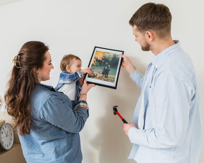 A woman choosing to be adopted by her stepmom and her brother refusing inheritance. A family hangs a picture in their new home. A woman choosing to be adopted by her stepmom and her brother refusing inheritance. A family hangs a picture in their new home.
