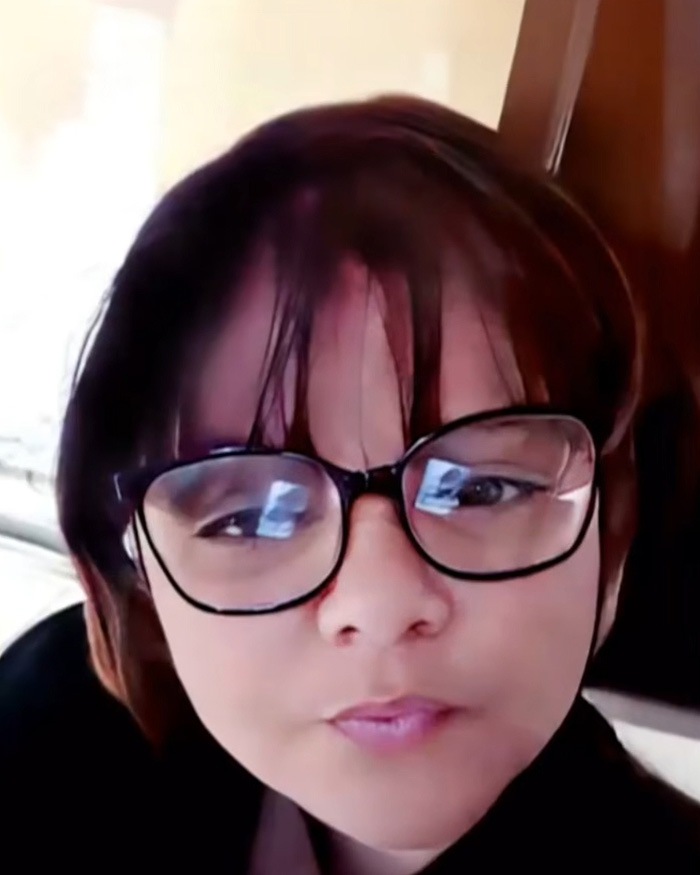 Close-up of a woman wearing glasses, the 38-year-old woman who tricked a kind couple.