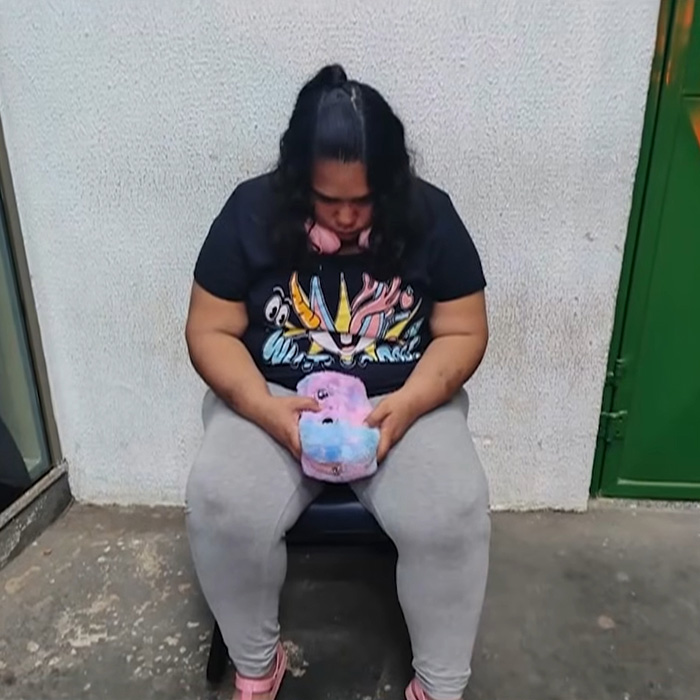 38YO woman sits, looking down, after tricking a kind couple into thinking she was a kid.