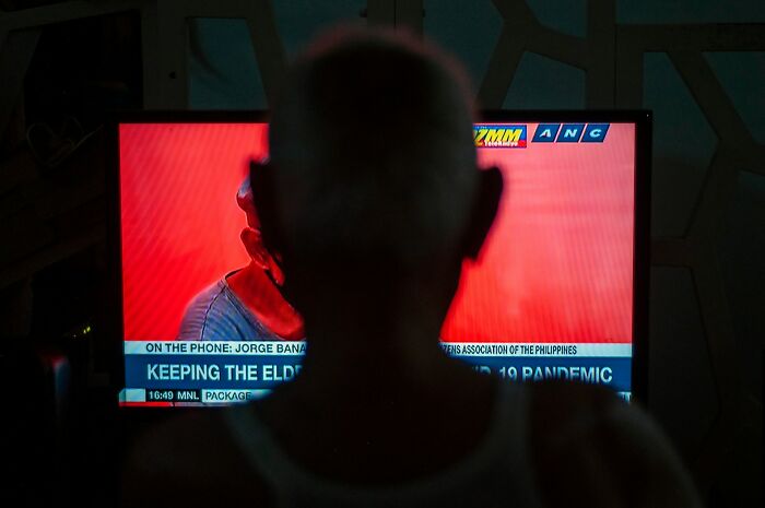 A person watches a TV, with interesting neighbors.