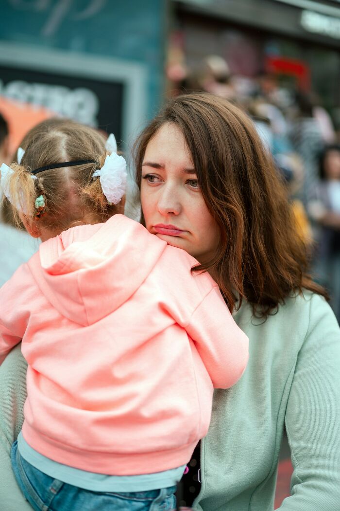 A sad parent holding a child, both looking unhappy. This image conveys the difficulties and emotional toll of being a horrible parent.