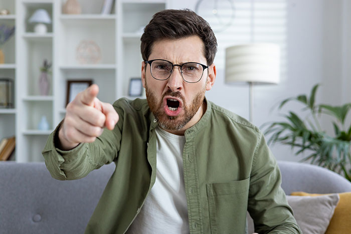 An angry man pointing, representing the exposed affair and taking down other cheaters before a group vacation. An angry man pointing, representing the exposed affair and taking down other cheaters before a group vacation.
