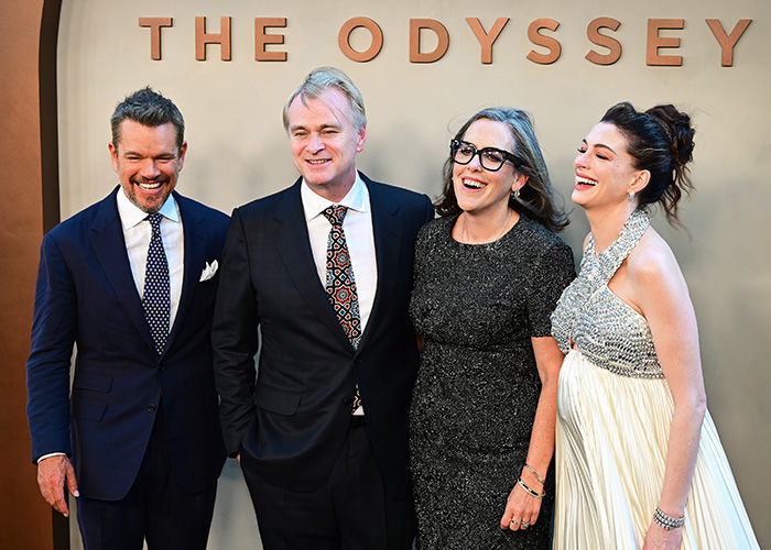 Anne Hathaway's red carpet maternity outfit with a white gown, posing with Matt Damon and other cast members.