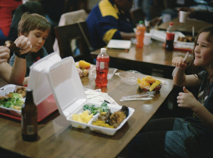 Children eating school lunch in the USA, showing meals in disposable containers on a table. Children eating school lunch in the USA, showing meals in disposable containers on a table.
