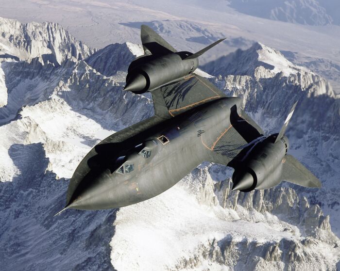 A high-speed spy plane, the SR-71 Blackbird, flying over mountains, representing the advanced aircraft tested at Area 51, not aliens. A high-speed spy plane, the SR-71 Blackbird, flying over mountains, representing the advanced aircraft tested at Area 51, not aliens.