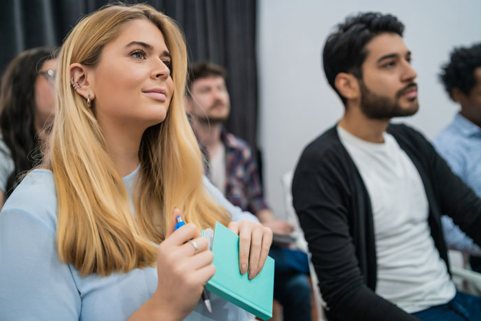 A woman attentively participating in a charity auction, ready to place bids. A woman attentively participating in a charity auction, ready to place bids.
