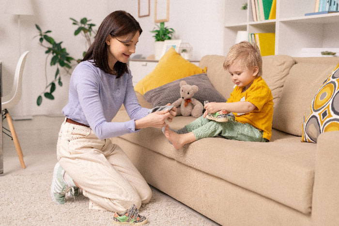 A babysitter playing with a child on a couch, illustrating a positive babysitting experience.